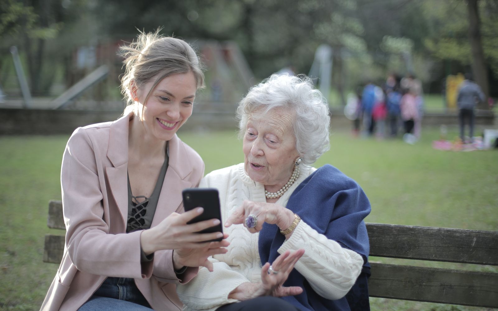 Adult child sitting beside a smiling senior parent at home
